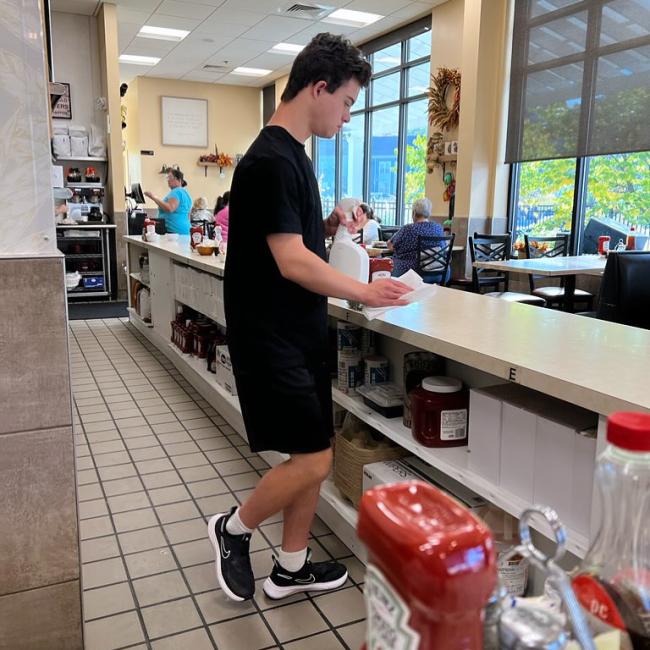 Man with Down syndrome wiping countertops 